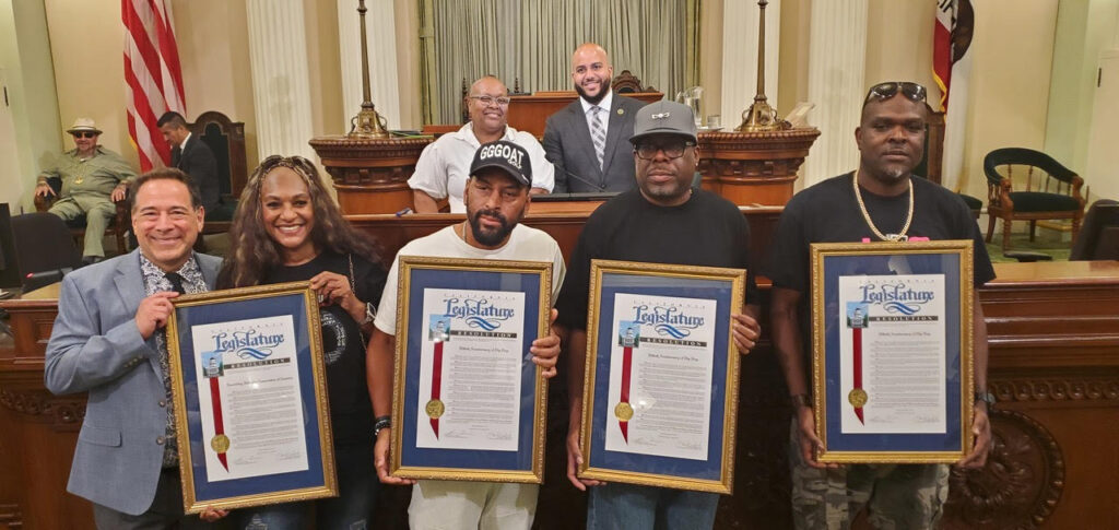 Pictured from left to right on the California Assembly floor with framed resolutions are: Joel Flatow (Senior VP of Recording Industry Association of America's West Coast Operations); Juana Burns-Sperling (co-founder of JJ Fad), Kim Renard Nazel (Arabian Prince), Roger McBride (King T), and Jon Owens (Casual from Oakland-based Hieroglyphics). Aug. 14, 2023. CBM Photo by Antonio Ray Harvey.