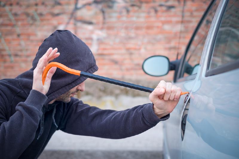 Petty crime (Thief picking lock of parked car) - Depositphotos